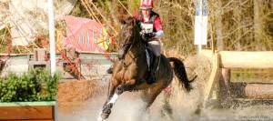 Buck Davidson riding through water on cross-country