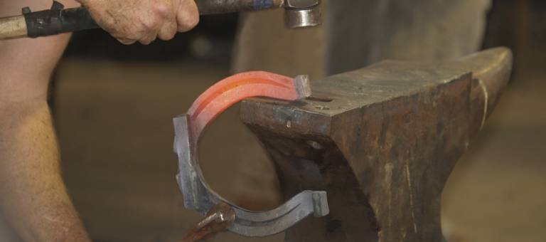 Farrier shaping a horseshoe